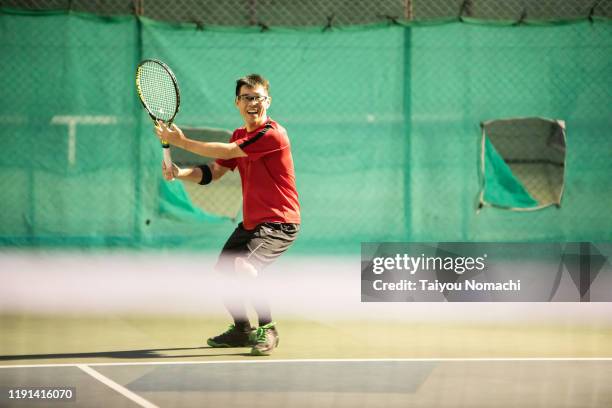 men hitting serve - schlägersport stock-fotos und bilder