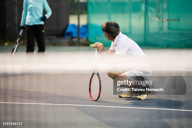 senior man sitting down during a tennis match - japanese tennis stock pictures, royalty-free photos & images