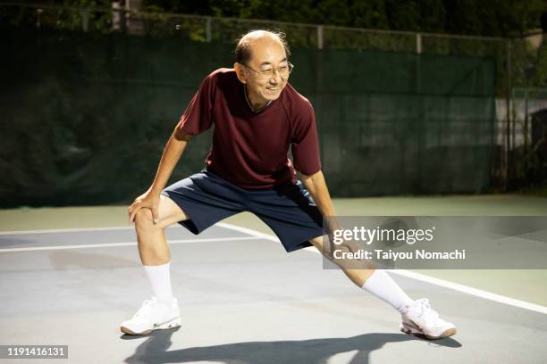 senior man doing stretching - japanese tennis photos et images de collection