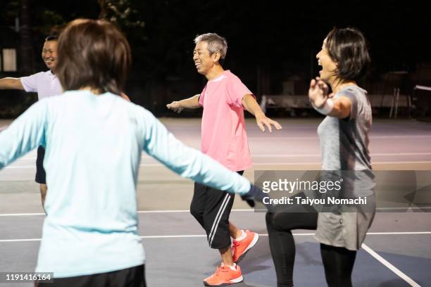 tennis team doing gymnastics in a circle - community figures foto e immagini stock