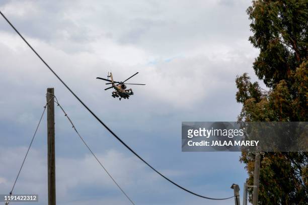 An Israeli army helicopter flies over the Israeli-annexed Golan Heights on January 3, 2020. - Israeli Prime Minister Benjamin Netanyahu cut short a...