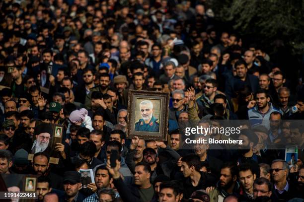 Protesters hold up an image of Qassem Soleimani, an Iranian commander, during a demonstration following the U.S. Airstrike in Iraq which killed him,...