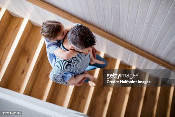 top view of mature father and small daughter indoors at home, walking down stairs. - family tree stockfoto's en -beelden