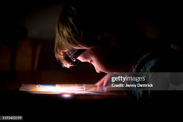 reading by torchlight - blackout picture stock-fotos und bilder