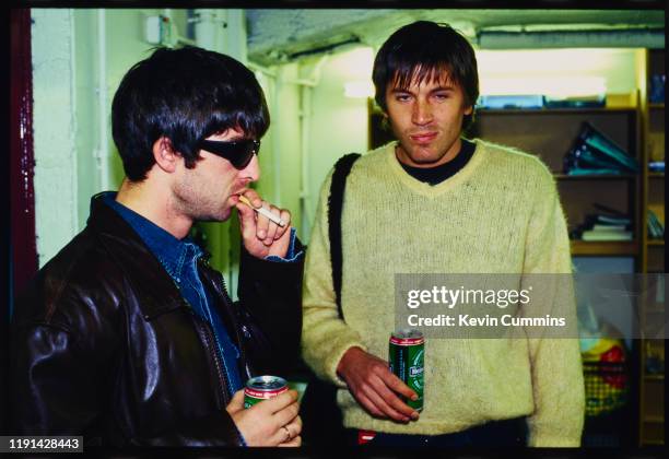 English musician and singer-songwriter Noel Gallagher of rock band Oasis with American musician Evan Dando of rock band The Lemonheads holding cans...