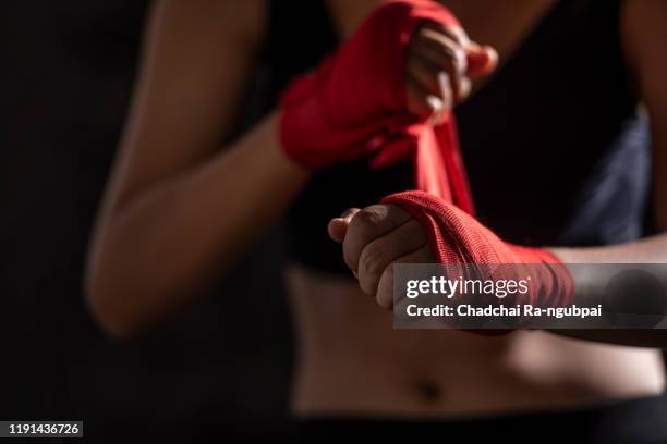 boxing bandage. close up of a sportsgirl binding red boxing bandage in a gym. - woman gym boxing stockfoto's en -beelden