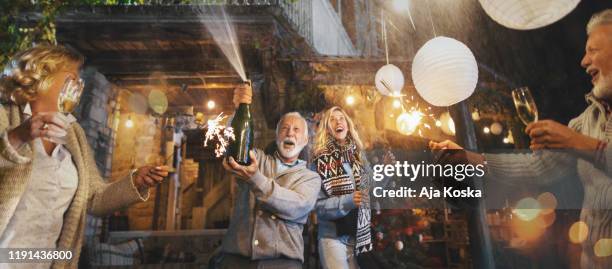 family new year's eve party. - champagne bottle popping stock pictures, royalty-free photos & images