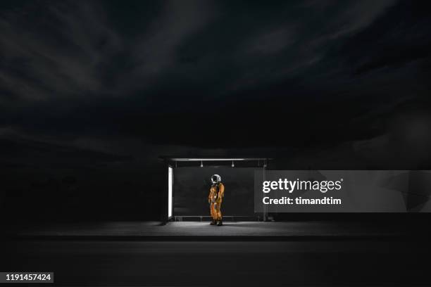 astronaut waiting at a bus stop - breakthrough concept stock-fotos und bilder