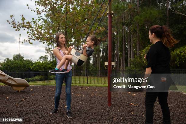 a trans woman playing with her daughter and wife on the playground
