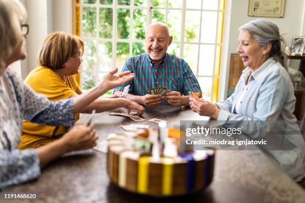 joyful elderly people having fun with cards - poker table stock pictures, royalty-free photos & images