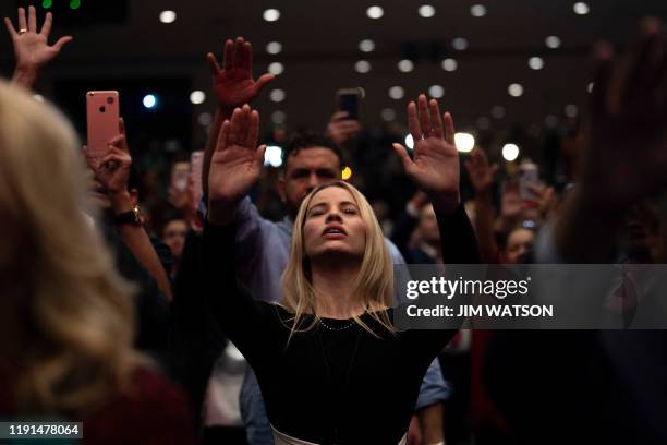 Supporters pray as US President Donald Trump speaks during a 'Evangelicals for Trump' campaign event held at the King Jesus International Ministry on...