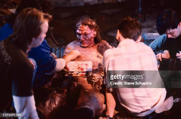 View of members of the special effects crew as they apply make-up to American actor Jeff Goldblum on the set of the film 'The Fly' , Los Angeles,...