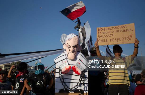 Protesters display a figure representing Chilean President Sebastian Pinera during the first protest of the year against the government, in Santiago...