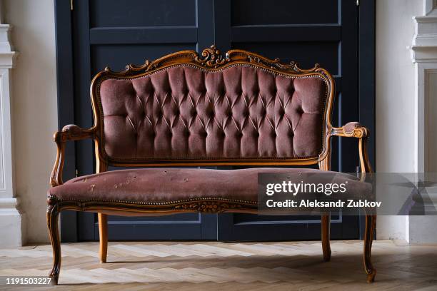 an old antique sofa, with holes in the fabric. - antique sofa styles foto e immagini stock