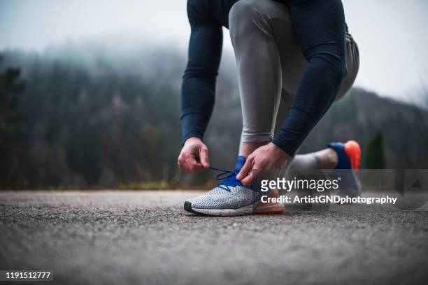 athlete tying shoelace outdoor. - amarrado imagens e fotografias de stock