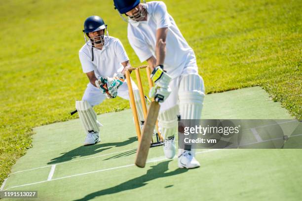 bateador de críquet golpeando la pelota - críquet fotografías e imágenes de stock