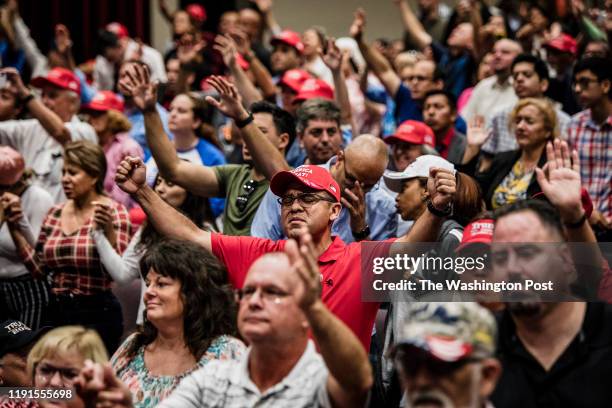 Attendees pray together before President Donald Trump addresses the crowd at the King Jesus International Ministry during a "Evangelicals for Trump"...