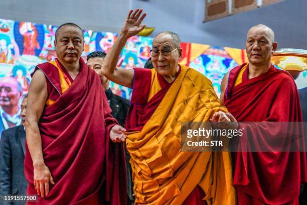 Tibetan spiritual leader the Dalai Lama waves to the crowd during the third day of a series of teachings in Bodhgaya on January 4, 2020.