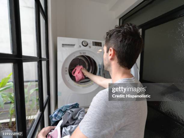 vue arrière de l'homme faisant la lessive à la maison - washing machine photos et images de collection