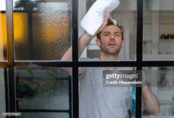 lateinamerikaner zu hause reinigung der fenster - mann putzen stock-fotos und bilder