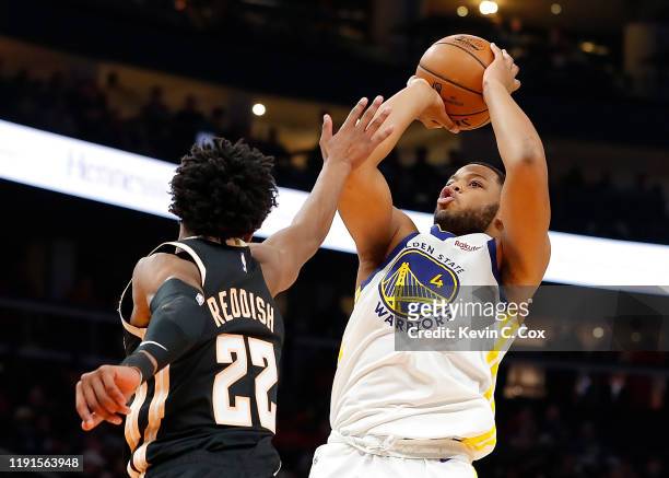 Omari Spellman of the Golden State Warriors attempts a shot against Cam Reddish of the Atlanta Hawks in the first half at State Farm Arena on...