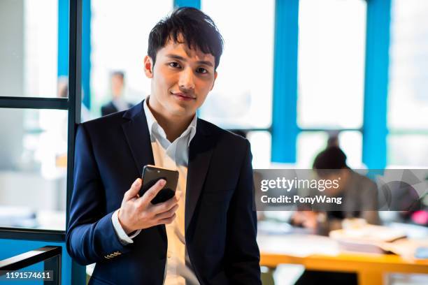 sourire asiatique d'homme d'affaires à vous - asian businessman phone photos et images de collection