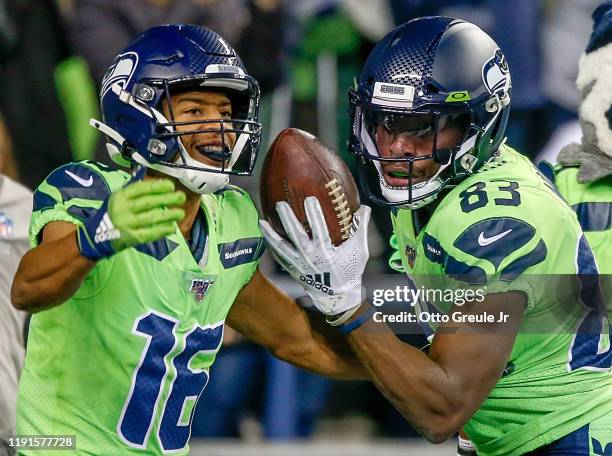 Wide receiver David Moore of the Seattle Seahawks celebrates a touchdown with Tyler Lockett in the third quarter of the game against the Minnesota...