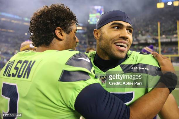 Russell Wilson and Mychal Kendricks of the Seattle Seahawks hug after the Seattle Seahawks defeated the Minnesota Vikings 37-30 during their game at...