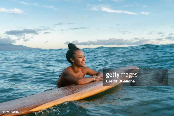 junge frau ruht sich auf ihrem surfbrett und wartet auf eine welle - beach holiday stock-fotos und bilder