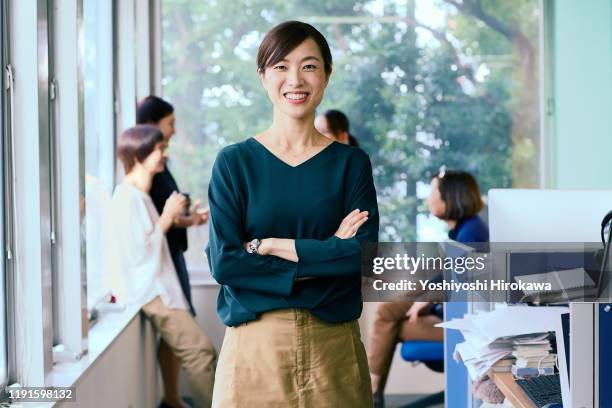 portrait of smiling working business woman and her team - japanischer abstammung stock-fotos und bilder