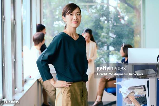 portrait of smiling working business woman and her team - japanischer abstammung stock-fotos und bilder