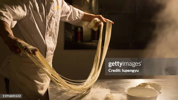 a chef is making a hand-pulled noodle,lanzhou - chinese noodles stockfoto's en -beelden