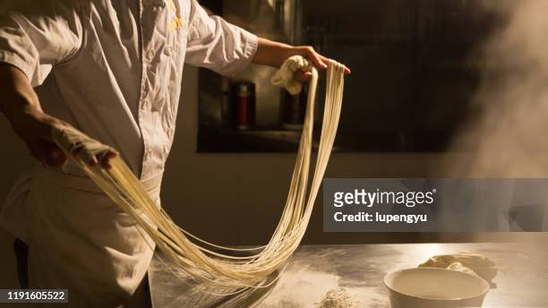 a chef is making a hand-pulled noodle,lanzhou - chinese restaurant stock pictures, royalty-free photos & images