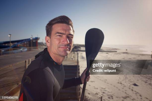 standup paddle board man with oar portrait at sunrise - midlife crisis stock pictures, royalty-free photos & images