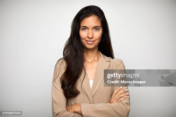 confident businesswoman over white background - beige jacke stock-fotos und bilder