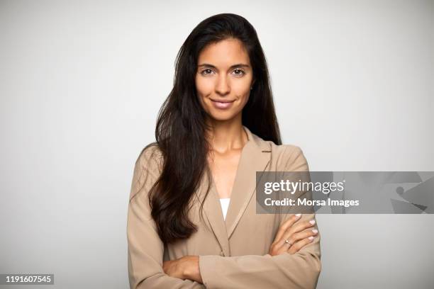 confident businesswoman over white background - beiger blazer stock-fotos und bilder