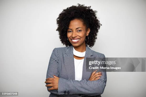 smiling businesswoman against white background - black blazer foto e immagini stock