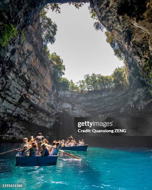 kefalonia, greece - august 22, 2019: tourists in a wooden boat deep in melissani lake cave in summer time - cefalónia imagens e fotografias de stock