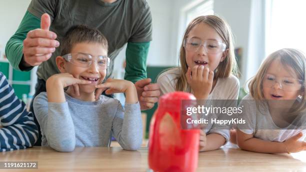 studenti che fanno esperimenti sul vulcano - reazione chimica foto e immagini stock