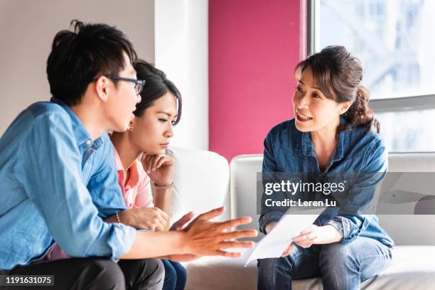 young couple communicate with financial consultant - chinese taipei stock-fotos und bilder