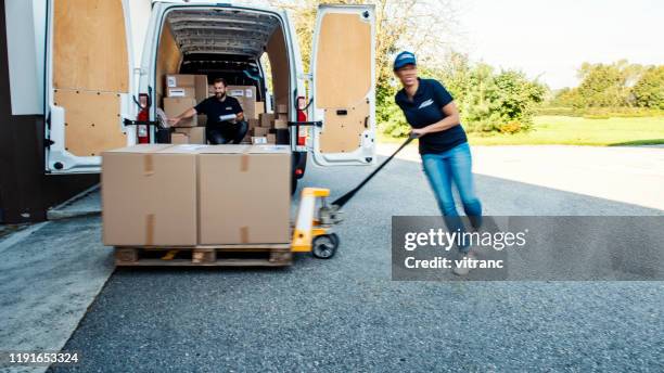 kleine groep mensen het lossen van de levering van - lossen stockfoto's en -beelden