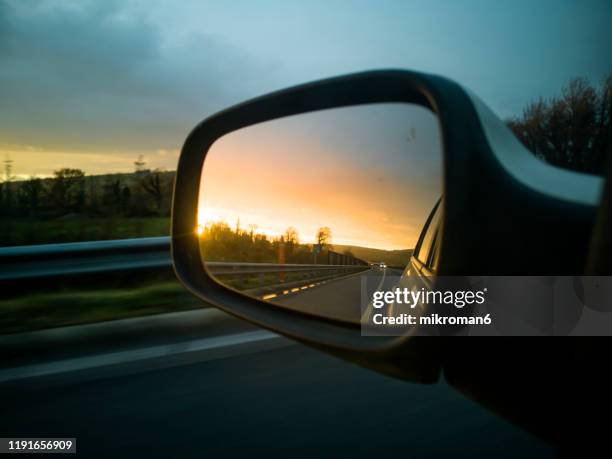 view of a car wing mirror. sunset time - rear view mirror 個照片及圖片檔