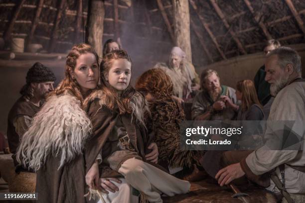 eine familiengruppe von wikinger-dorfbewohnern in einer authentischen wikingersiedlung - village home indoor stock-fotos und bilder