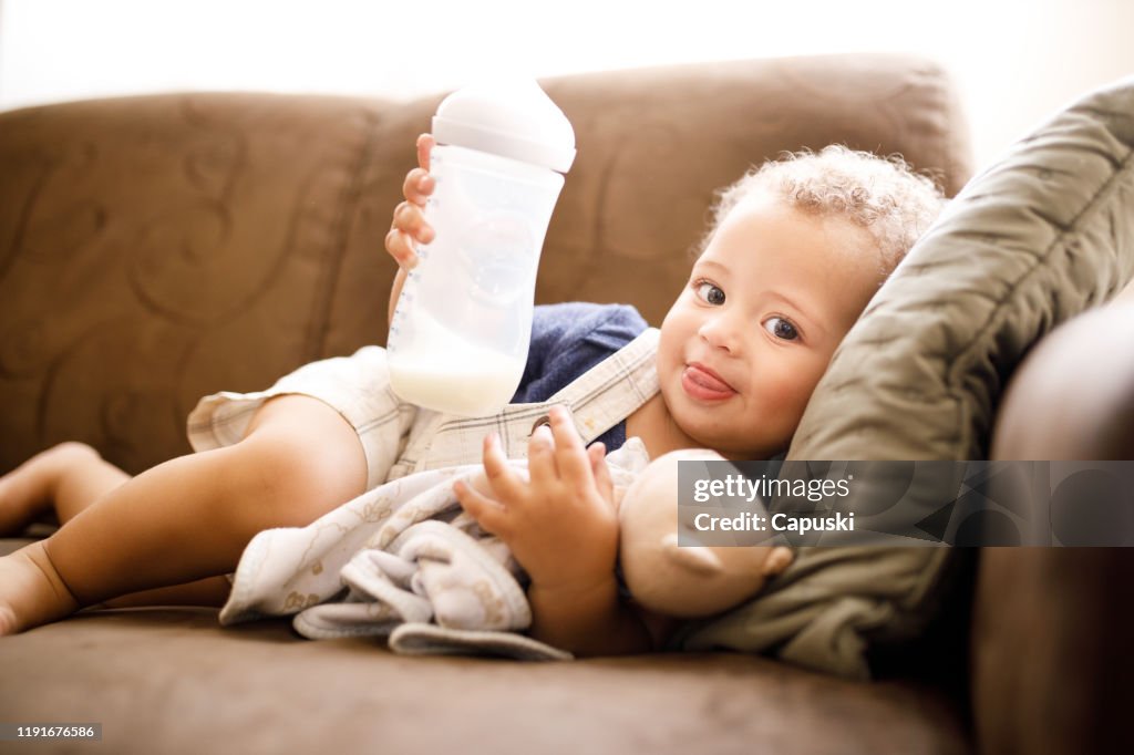 Baby holding milk bottle