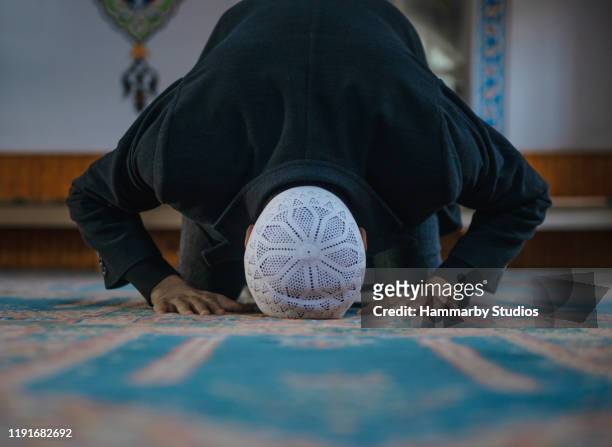 close-up shot van een moslim jonge man aanbaden in een moskee - bidden stockfoto's en -beelden