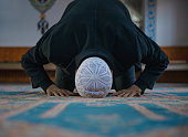 Close-up shot of a Muslim young man worshiping in a mosque