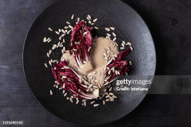 fresh baby radicchio with white bean dressing sauce and sunflower seed - radicchio stockfoto's en -beelden