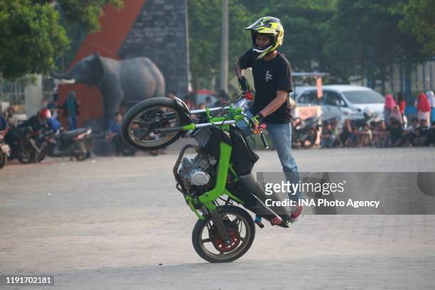 Teenager performs a Free Style action using a motorcycle in the parking area of ​​the Sumpah Pemuda Way Halim Stadium, Bandar Lampung, Indonesia,...