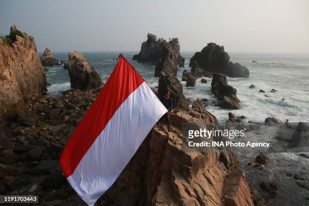 An Indonesian man seen carrying the Indonesian flag, on the rock of Tanggamus, Lampung, on August 16 in commemoration of the 74th Independence Day of...