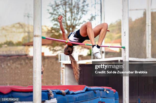 girl jumping on the high bar, on her back, with a beautiful technique - courses in santander fotografías e imágenes de stock